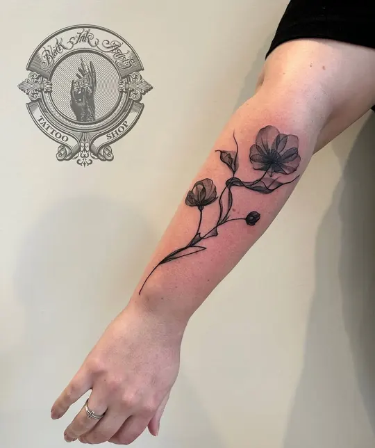 Fine-line X-ray style flowers on the forearm