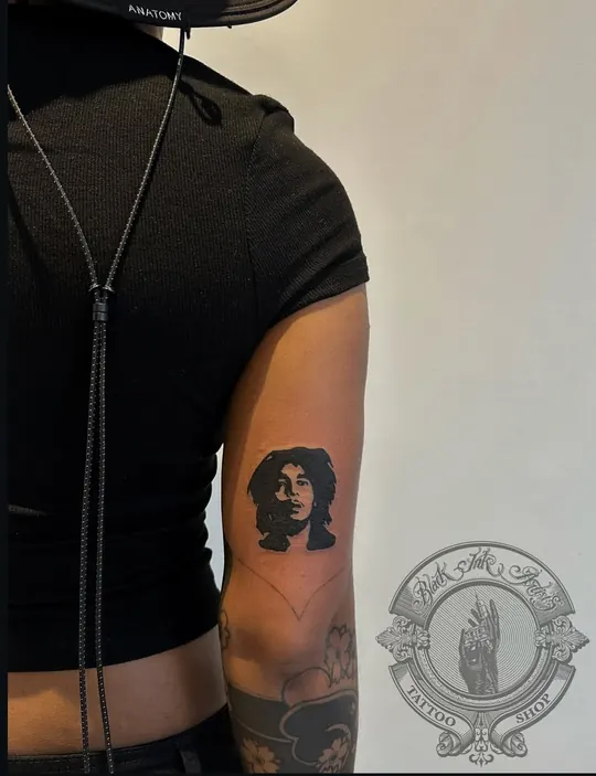 Blackwork portrait tattoo on the upper arm