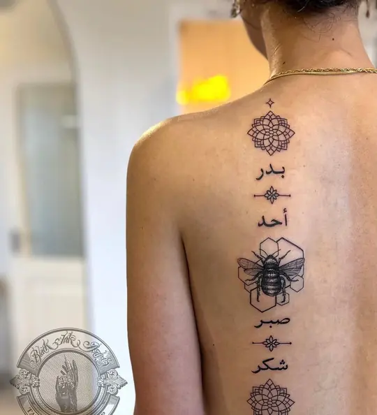 Ornamental tattoo running down the spine
